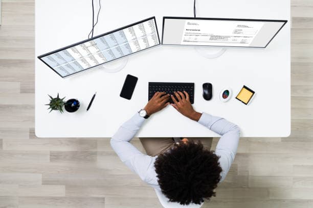 Person tailoring their CV on a laptop with a job description open